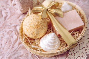 Doğal bambu malzeme sepeti. Paramparça ahşap mükemmeliyetçilikle dolu. Çeşitli spa banyo ürünleri, pembe sabun çubuğu, banyo bombası, klasik açık pembe arka planda doğal sünger. Güzellik hediyesi.