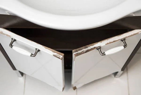 Su hasarlı yüksek parlak beyaz MDF banyo süs dolabı kapısı pervazlı. Nemli banyo durumu konsepti.