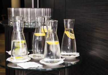 Ahşap zemin üzerinde limon suyu olan saydam sürahiler..