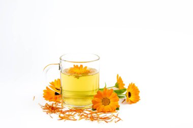 Calendula officinalis the pot marigold, ruddles, common marigold veya Scotch marigold, temiz bardakta çiçek çayı, tıbbi tedavi kavramı..