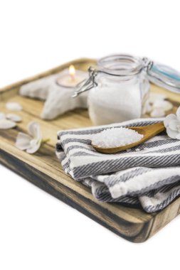 Okyanus temalı cam kavanozdaki deniz tuzu seti ve tahta kaşıkta tahta tepside, mum yanığı, dekorasyon için deniz kabukları, beyazda izole edilmiş. Güzellik ve yemek konsepti. 