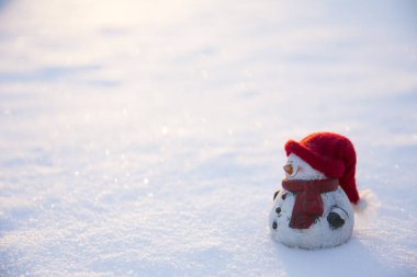 Beyaz kardan adam figürü, sıcak şapkası ve eşarbı karda duruyor, güneş kışın açık havada batıyor, bir sürü fotokopi alanı var..