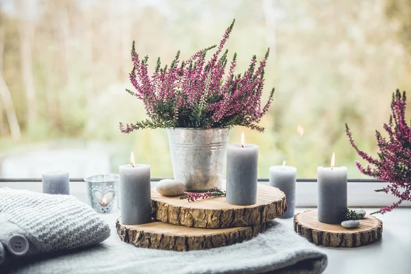 为秋天的到来做准备 窗台上有一套舒适的季节性装饰 灰色的蜡烛点燃 普通的粉红色石南花在锌桶花盆 舒适家居装修的概念 — 图库照片