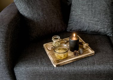 Minimalist İskandinav tarzı siyah renk ev dekoru kavramına yakından bakın. Buharda pişirilmiş bitki çaylı ahşap tepsi, aydınlatılmış siyah mum, geyik boynuzu, çam kozalağı. Üst görünüm.