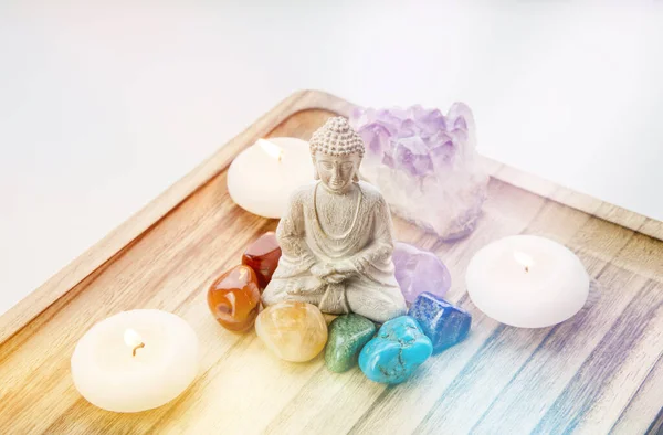 所有7个脉轮颜色水晶围绕着坐在自然木盘上的佛像 家庭观念中的平衡与平静的能量流 — 图库照片