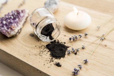 Güzellik ürünleri konseptinde çiğ kömür tozu. Bir sürü kopya alanı var. Spa mumu yanıyor..