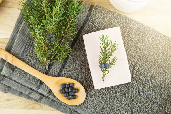 Düz görünüm Juniper latin Juniperus communis berry sabun barı, daha güvenilir konileri olan ardıç ağacı dalı ve böğürtlenli kaşık, kopyalama alanı. Güzellik kozmetik konseptinde ardıç ağacı meyvesi ve yağ.