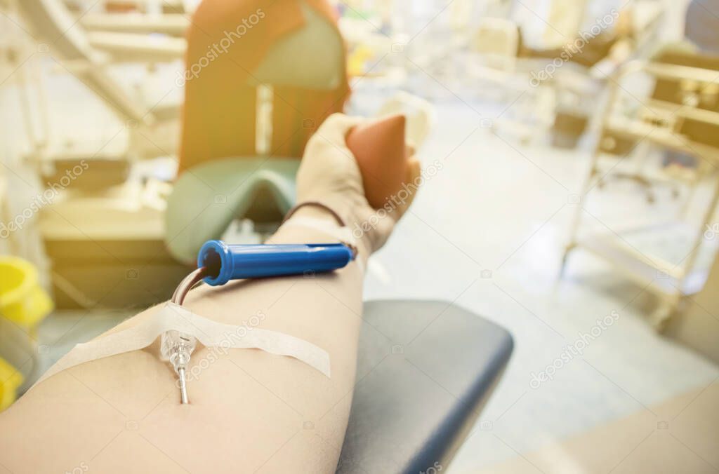 Close up view of woman arm hand with blood donation equipment. Woman donor donating blood concept.