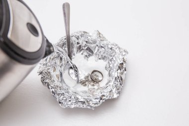 Kabartma tozu (sodyum bikarbonat) ve sıcak su çözeltisi, gümüş bir parça alüminyum folyoyla temas ettiğinde gümüşten lekeyi temizleyecektir. Gümüşün üzerine sıcak su dök.