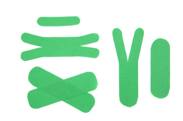Set of diffrent shape and size green sport elastic kinesio therapeutic tape, also called kinesiology tape strips isolated on white background. Flat lay top view.