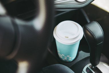 Arabanın bardak tutacağında mavi kağıt kahve fincanı. Araba konseptinde kahve içmek için kahve..