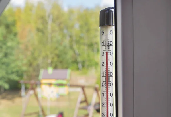 Outdoor thermometer indicate over 30 degrees celsius outdoor in summer.