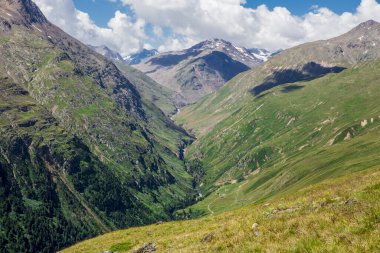 Yazın Avusturya Apls 'da seyahat etmek, uzakta geleneksel evler, solda vadi. Havalandırma adı verilen köyün yakınında..