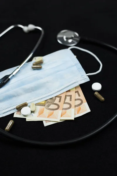 Health Care Industry concept. Top view of the doctors instruments and euro money, isolated on black.