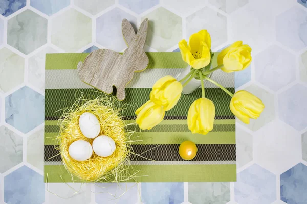 桌上五彩缤纷的复活节装饰品 鸟巢里的鸡蛋 白色花瓶里的黄色郁金香 — 图库照片