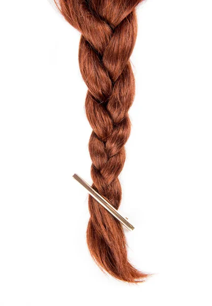 コピースペースと白の背景に隔離されたシンプルな現代的なヘアクリップと緑豊かな銅赤い髪で作られたシンプルな編組尾 ヘアプロダクト背景コンセプト — ストック写真