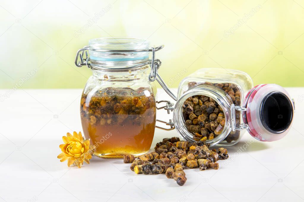 Alternative medicine mixture made with honey and bee bread ( fermented flower and plant pollen by honey bees) inside small glass jar.