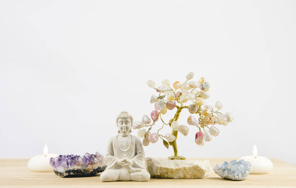 Успокаивающий медитационный фон с сидящим медитирующим Буддой, кристаллические скопления (фиолетовый аметист и синий аметит) и дерево из драгоценной проволоки белый минималистский фон с копировальным пространством
.