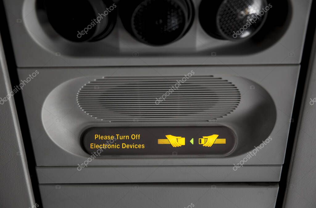 Close-up view of Please turn off electronic devices and fasten your seat belt in passenger airplane. Safety concept.