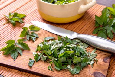 İlkbaharda taze gutweed yapraklarını yemek için kullanırlar. Aegopodyum podagraria genellikle yaşlı olarak bilinir, ot gerard, piskopos otu, gut otu. Kesme tahtasında doğranmış yapraklar, hazırlıklar.