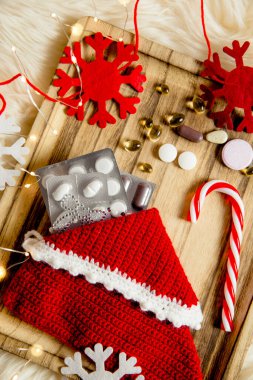 Farklı hapların vitaminlerinin en üst görüntüsü Noel hediyesi olarak kaliteli ahşap tepside duran terlik içinde keçeli kar tanelerini süslemek için. Hediye fikri.