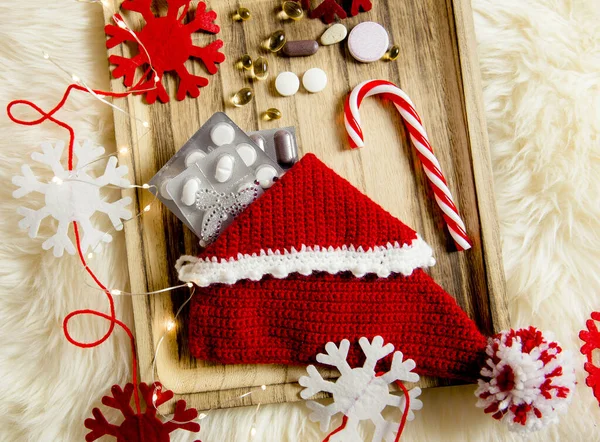 将不同药丸维生素作为圣诞礼物放在老式木制盘子里的拖鞋长袜里 用毛毡雪片做装饰 礼物的概念 — 图库照片