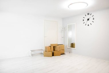 Yeni bir ev kavramına geçiyorum. Beyaz minimalist beyaz ev koridorundaki karton kutular. Taşınmayı bekliyor. Metin için çok yer var..
