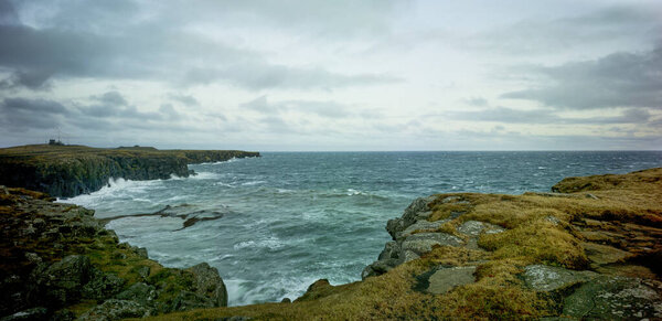 Линия скалы на побережье Исландии с травяными породами и мхом
