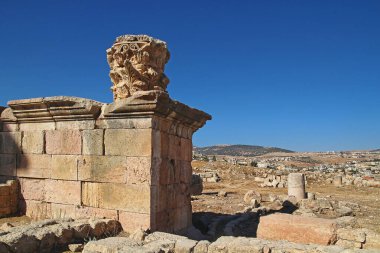 Ürdün 'ün Jerash kentindeki antik Roma şehrinin tepesinden, yazın modern Orta Doğu şehrinin arka planına bakın..