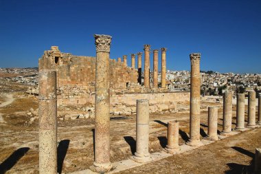 Ürdün 'ün Jerash kentindeki antik Roma şehrinin tepesinden, yazın modern Orta Doğu şehrinin arka planına bakın..