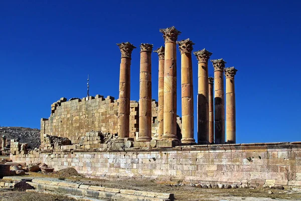 Ürdün 'ün Jerash kentindeki antik Roma şehrinin tepesinden, yazın modern Orta Doğu şehrinin arka planına bakın..