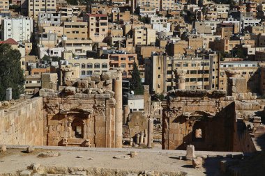 Ürdün 'ün Jerash kentindeki antik Roma şehrinin tepesinden, yazın modern Orta Doğu şehrinin arka planına bakın..