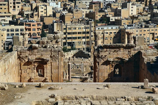 Ürdün 'ün Jerash kentindeki antik Roma şehrinin tepesinden, yazın modern Orta Doğu şehrinin arka planına bakın..