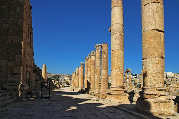 Ürdün 'ün Jerash kentindeki antik Roma şehrinin tepesinden, yazın modern Orta Doğu şehrinin arka planına bakın..