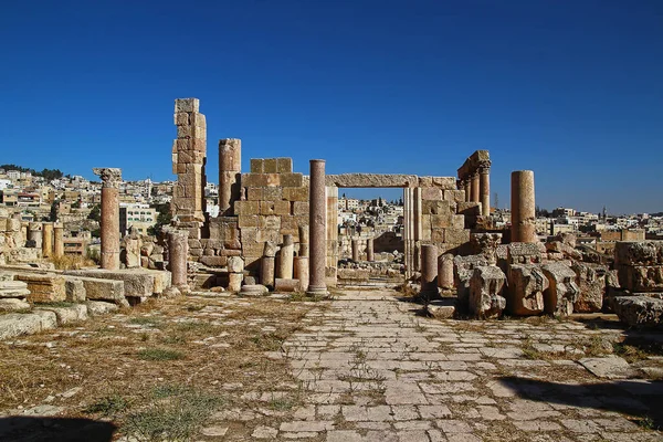 Ürdün 'ün Jerash kentindeki antik Roma şehrinin tepesinden, yazın modern Orta Doğu şehrinin arka planına bakın..