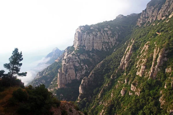   ,             .     .Montserrat bir Benedikt manastırı, bir ruhani sembol ve Katalonya 'nın dini merkezi ve dünyanın dört bir yanından gelen Katolikler için bir hac merkezidir. Bulutlarla kaplı bir manastırın çarpıcı manzarası.