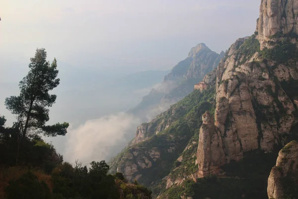   ,             .     .Montserrat bir Benedikt manastırı, bir ruhani sembol ve Katalonya 'nın dini merkezi ve dünyanın dört bir yanından gelen Katolikler için bir hac merkezidir. Bulutlarla kaplı bir manastırın çarpıcı manzarası.