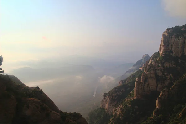   ,             .     .Montserrat bir Benedikt manastırı, bir ruhani sembol ve Katalonya 'nın dini merkezi ve dünyanın dört bir yanından gelen Katolikler için bir hac merkezidir. Bulutlarla kaplı bir manastırın çarpıcı manzarası.