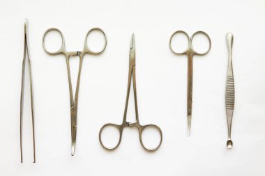 Doktor araçları, curettage, kramplar, pens ve makas beyaz arkaplan üzerinde kopyalama alanı ile
