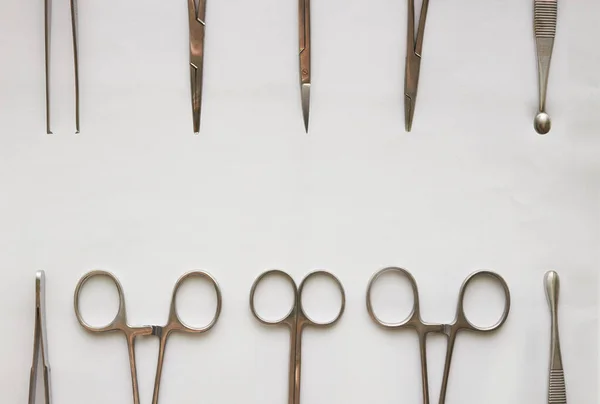 Doktor araçları, curettage, kramplar, pens ve makas izole edilmiş beyaz arkaplan üzerinde kopyalama alanı ile