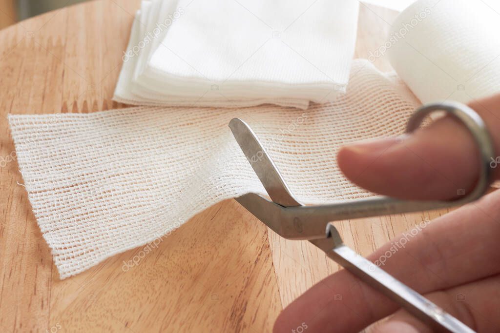 Dressing or clean wound tools includes Roll gauze,pile of gauzes and gauze roll cutter or scissors with Hand cut gauze