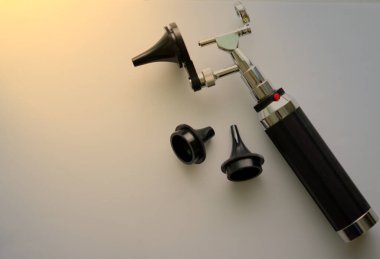 Kulak kontrolü için otoskop. Doktor ENT için. Fotokopi alanı olan bulanık arkaplan üzerine üç ölçekli spekülasyon parçaları.