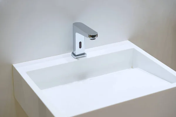 Ellerini yıkamak için musluğu olan temiz bir lavabo.