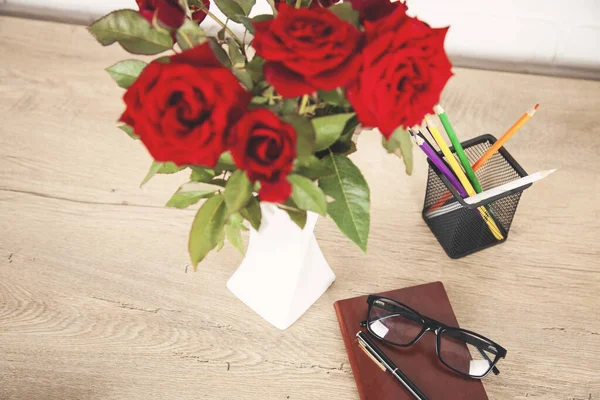 notepad and flower on the wooden  desk