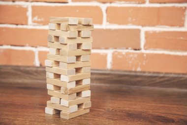 Ahşap mimari küpleri tuğla duvar arka planındaki masada.