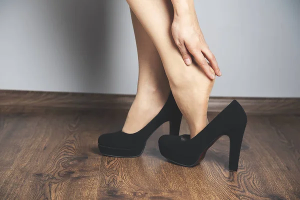 Женщина Болят Ноги Обувь Сером Фоне Стены — стоковое фото