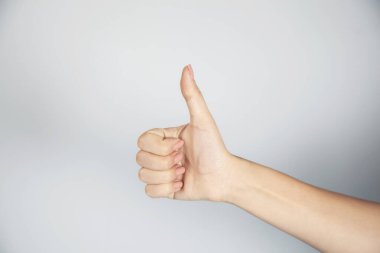Kadın parmağı Evet işareti gri arka planda