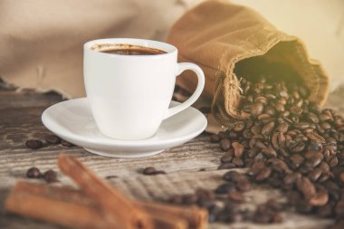 Kahve taneleri ve kahve fincanları masanın üstünde.