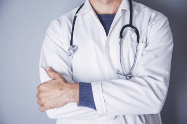 Doktor elini arka planda çaprazladı.