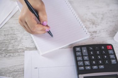 İş kadını el kalemi ve not defteri ofis masasında.
